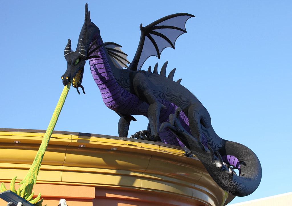 A dramatic scene of Maleficent transformed into a dragon, facing off against Prince Phillip